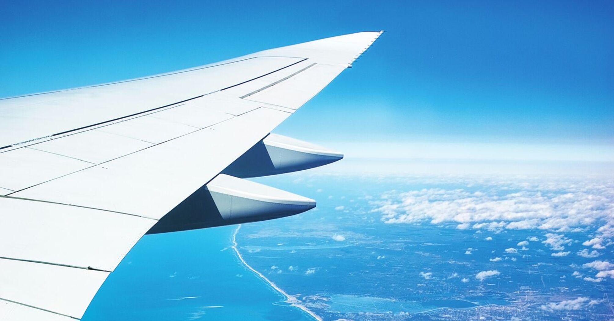 The photo shows an airplane wing viewed from the window during flight
