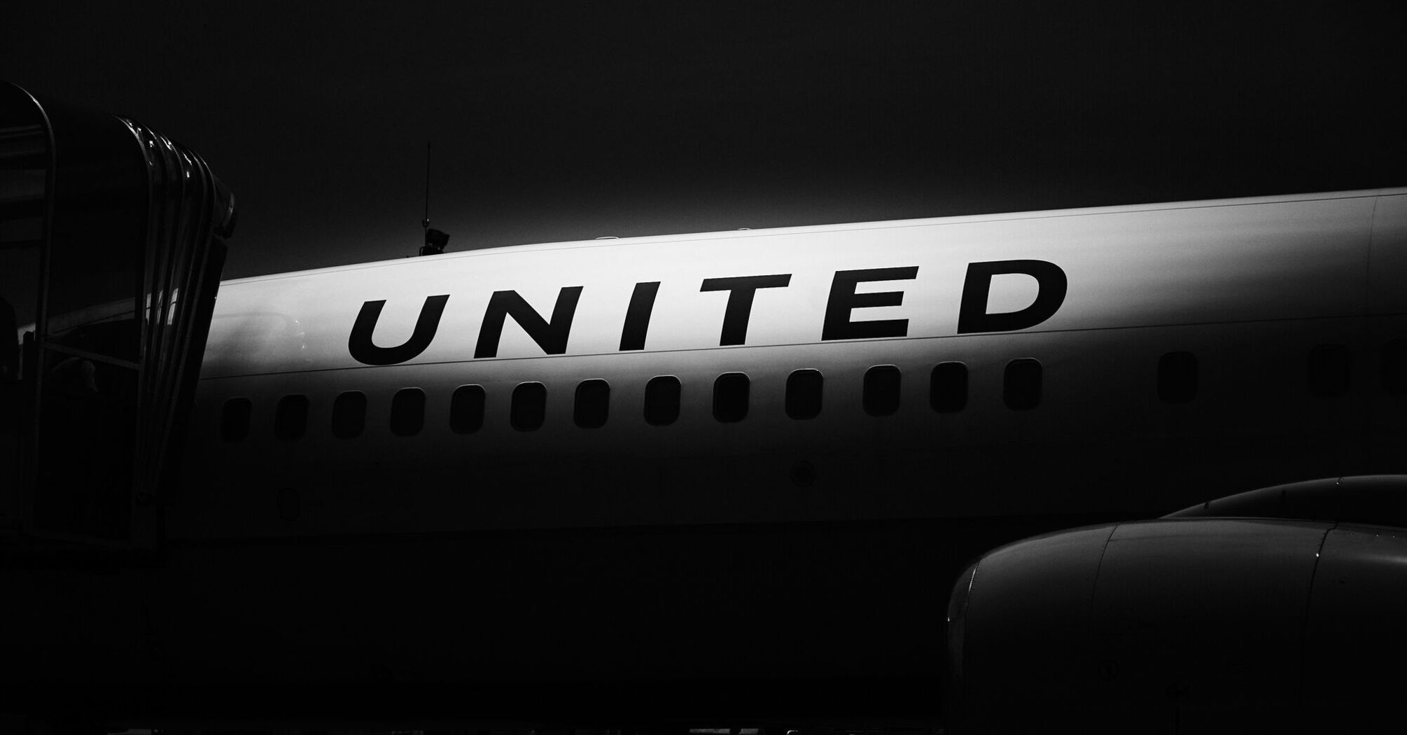 Close-up shot of a United Airlines airplane showing the word 'UNITED' on the side in black and white