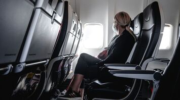 An airplane cabin with a passenger looking out the window