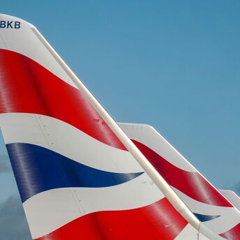 Tail fins of a British Airways aircraft with a blue sky in the background
