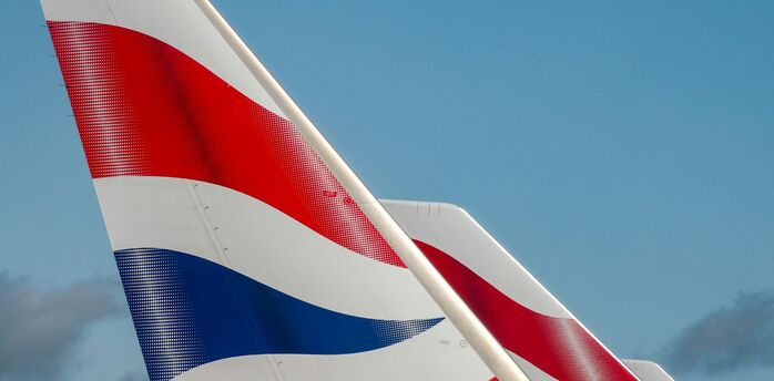 Tail fins of a British Airways aircraft with a blue sky in the background