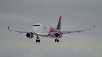 A large jetliner flying through a cloudy sky