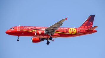 Red and yellow airplane in mid air during daytime