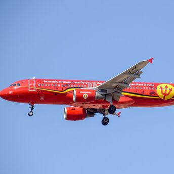Red and yellow airplane in mid air during daytime