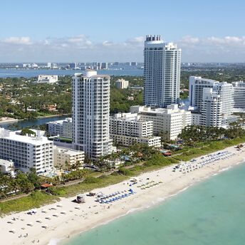 Aerial view of Miami beachfront with high-rise hotels and beachgoers