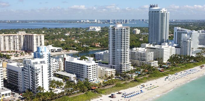 Aerial view of Miami beachfront with high-rise hotels and beachgoers