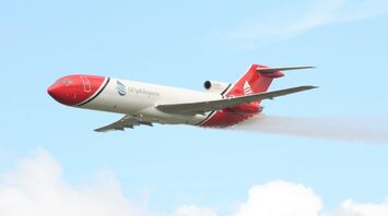 A large jetliner flying through a blue cloudy sky