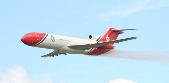 A large jetliner flying through a blue cloudy sky