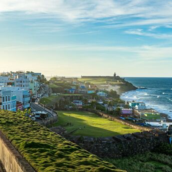 View of a colorful coastal San Juan with a vibrant landscape along a seashore, under a clear blue sky