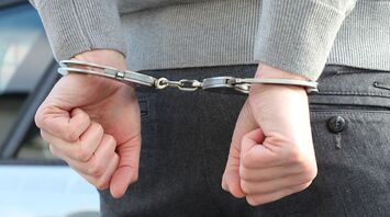 Person in handcuffs with hands behind their back 