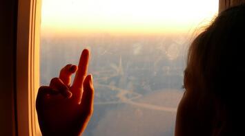 Little girl looking out the airplane window