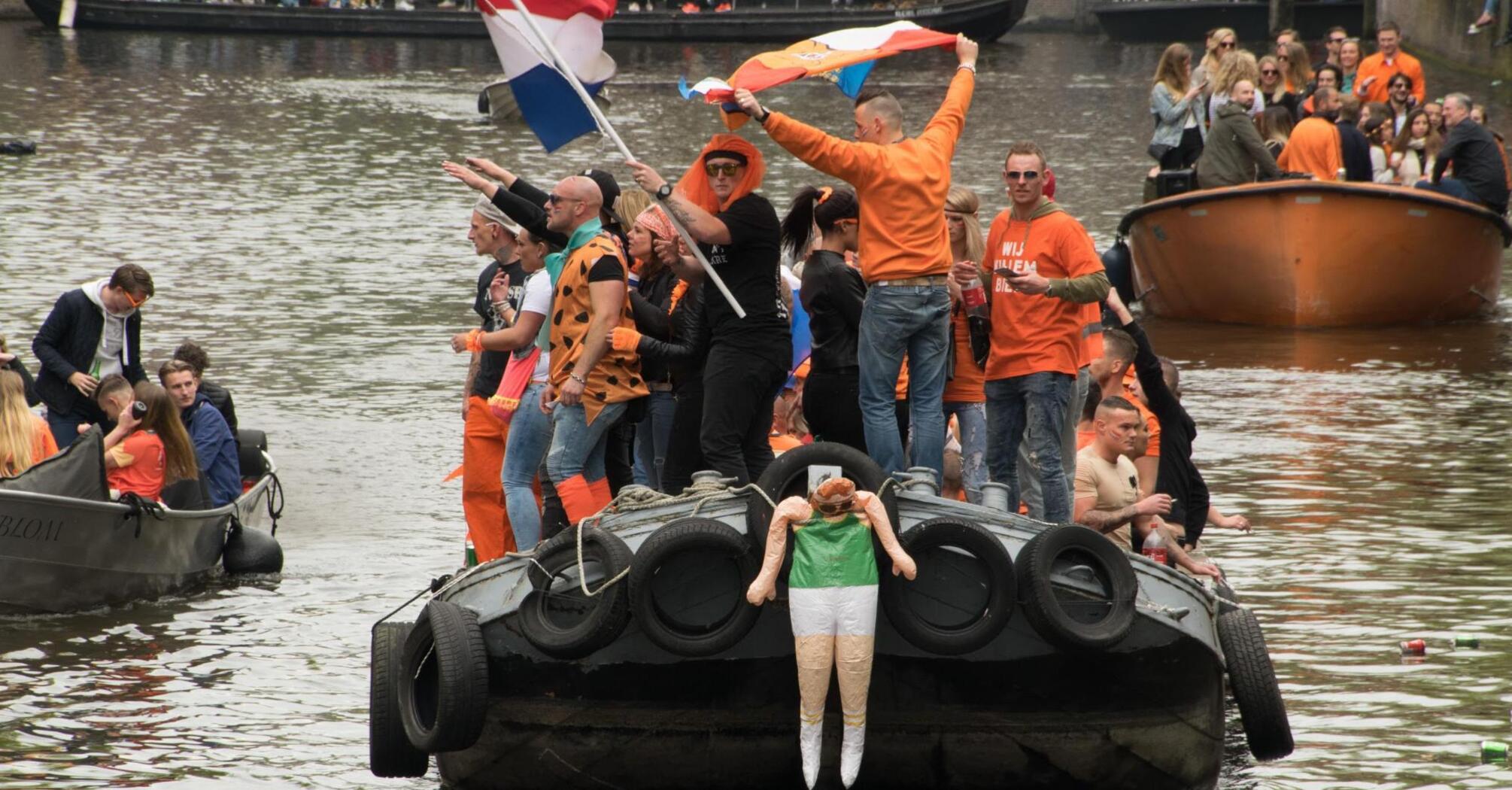 Three boats with people on the river in orange clothes