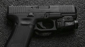 A black handgun on a dark textured surface