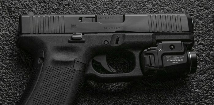 A black handgun on a dark textured surface