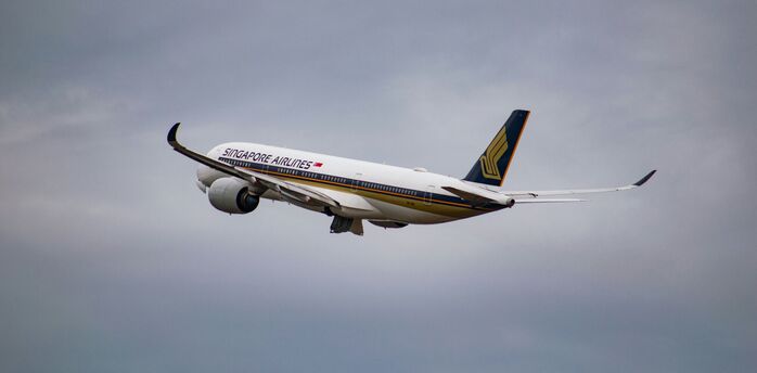 White singapore airlines airplane flying during cloudy day