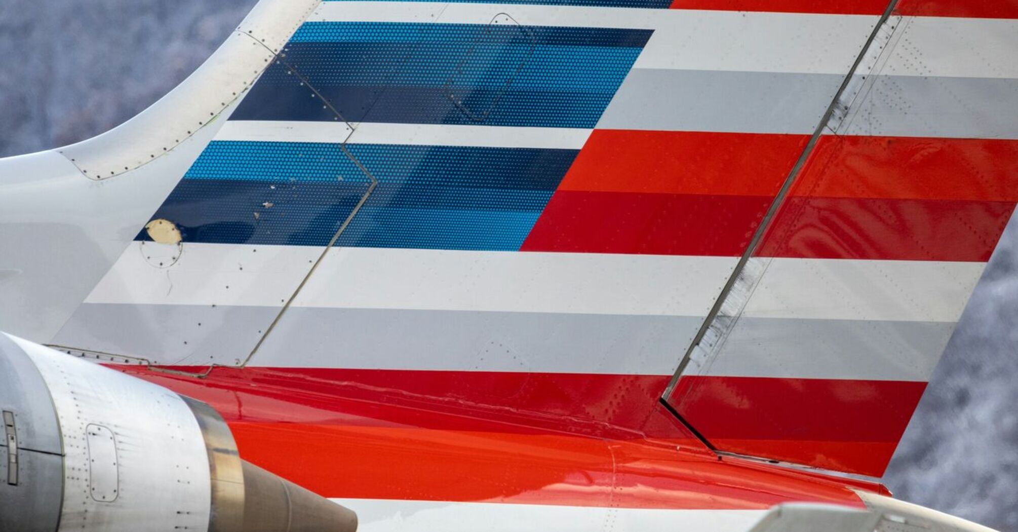 The tail section of an American Airlines airplane with red, white, and blue stripes