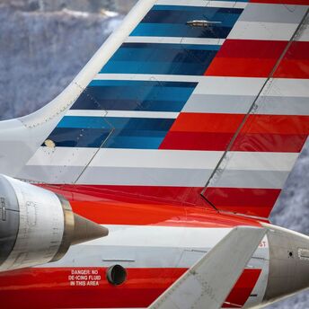 The tail section of an American Airlines airplane with red, white, and blue stripes