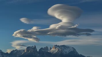 White clouds over snow covered mountains