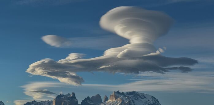 White clouds over snow covered mountains