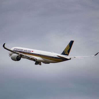White Singapore airlines airplane flying during cloudy day