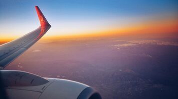 Photograph white and red airplane wing