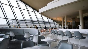 People sitting on white chairs inside building