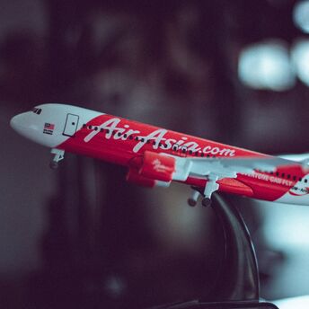 A model of an AirAsia airplane on a stand with a blurred background 
