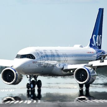 SAS aircraft taxiing on a runway, showcasing the distinctive blue tail logo 