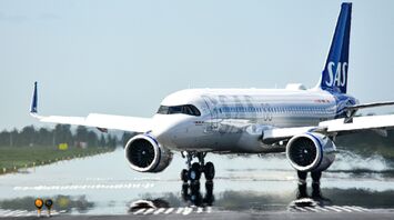 SAS aircraft taxiing on a runway, showcasing the distinctive blue tail logo