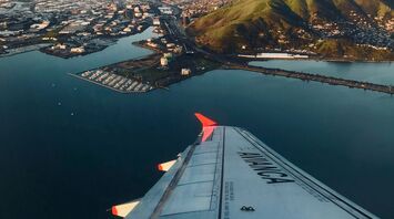 View from Avianca airplane window over coastal city at dawn