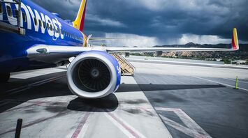 Passenger plane on airport under gray cloudy sky