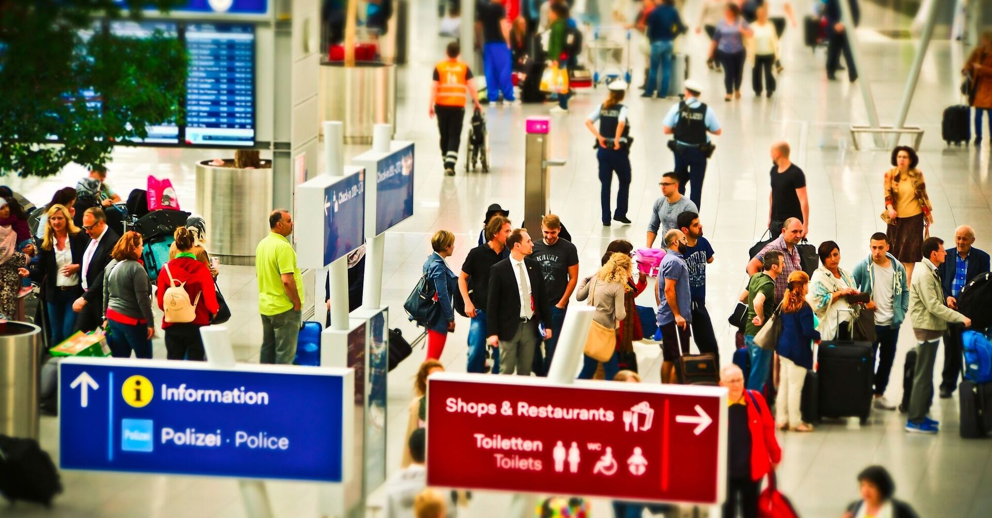 Busy airport terminal with travelers and directional signs
