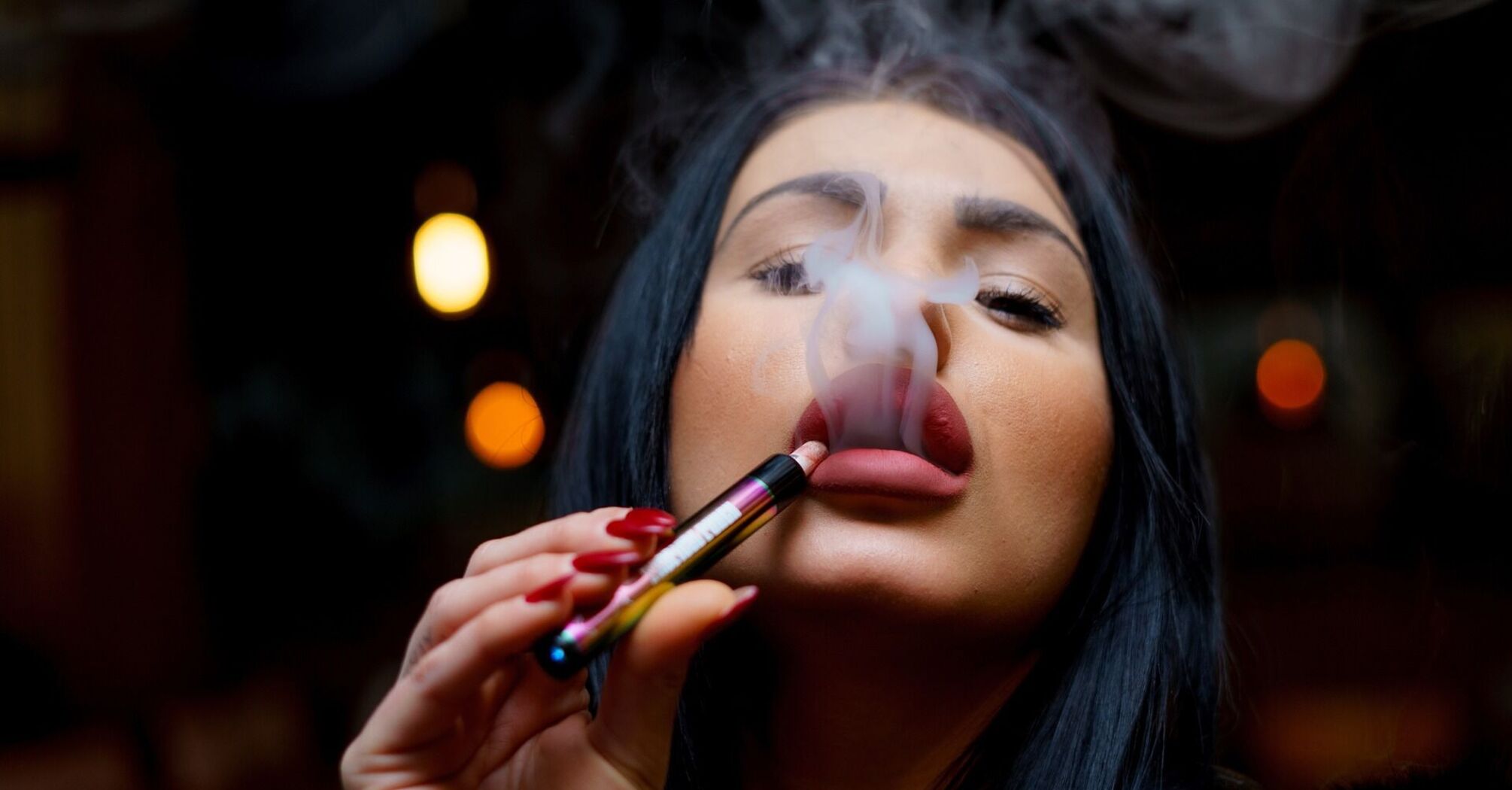 Woman exhaling vapor from an electronic cigarette