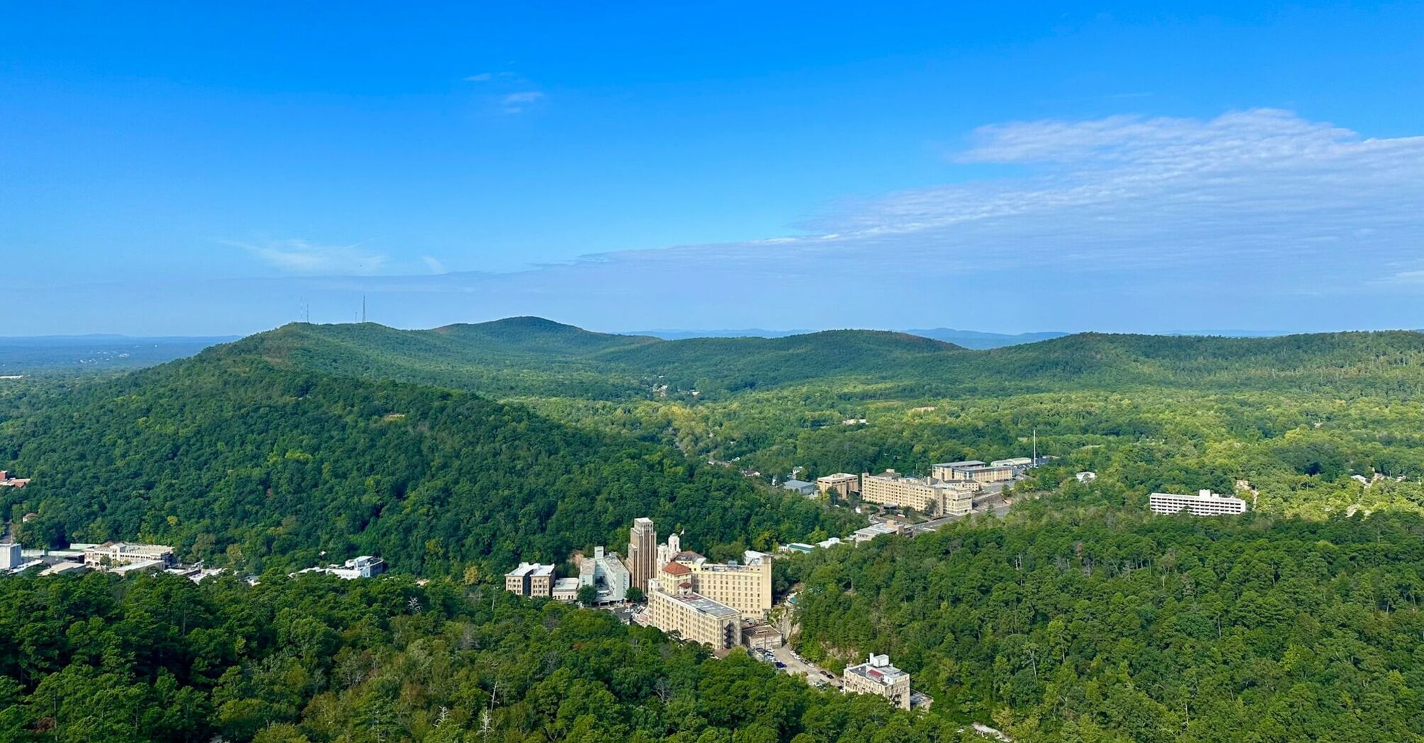 Aerial view of Hot Springs National Park with green hills and buildings nestled among forests in Hot Springs, Arkansas, USA