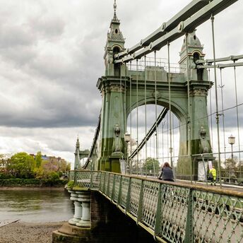 Hammersmith Bridge with pedestrians and overcast skies