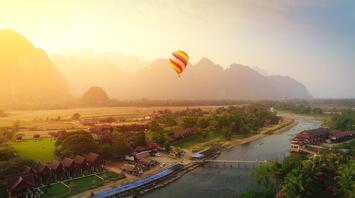 Air balloon over river and houses