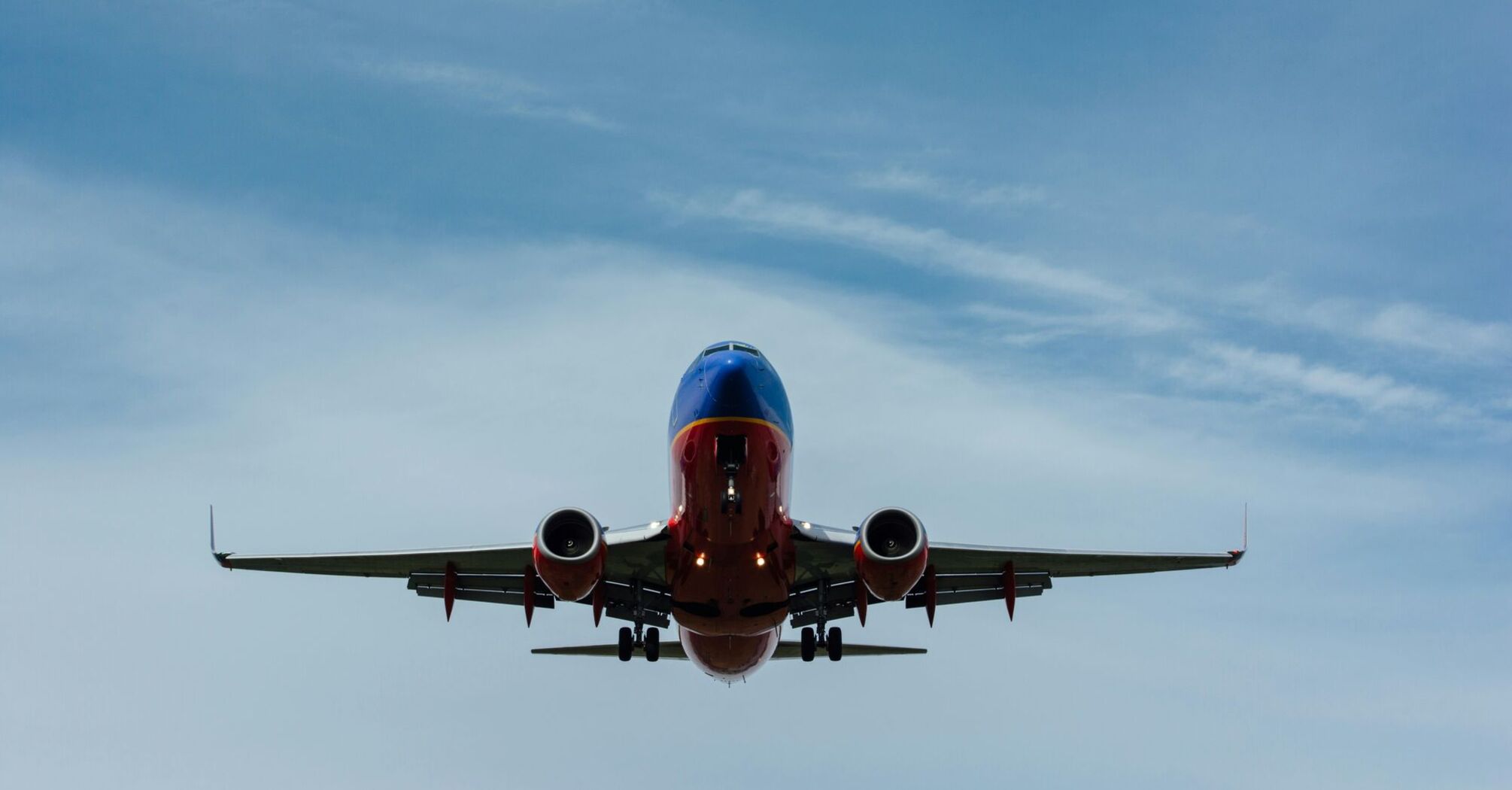 Blue and red airplane on sky