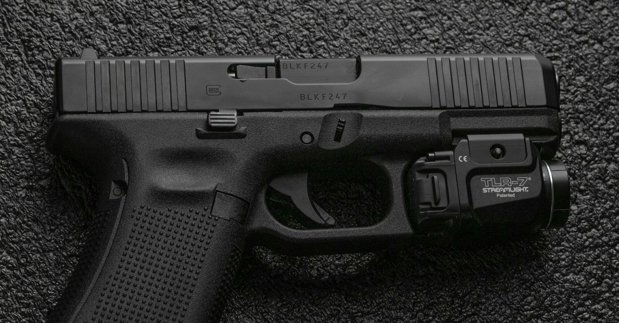 A close-up image of a handgun resting on a textured surface