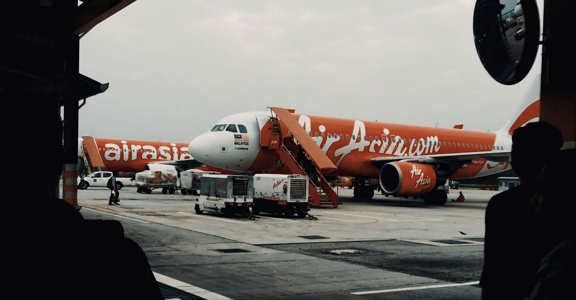AirAsia aircraft at boarding gate with overcast skies