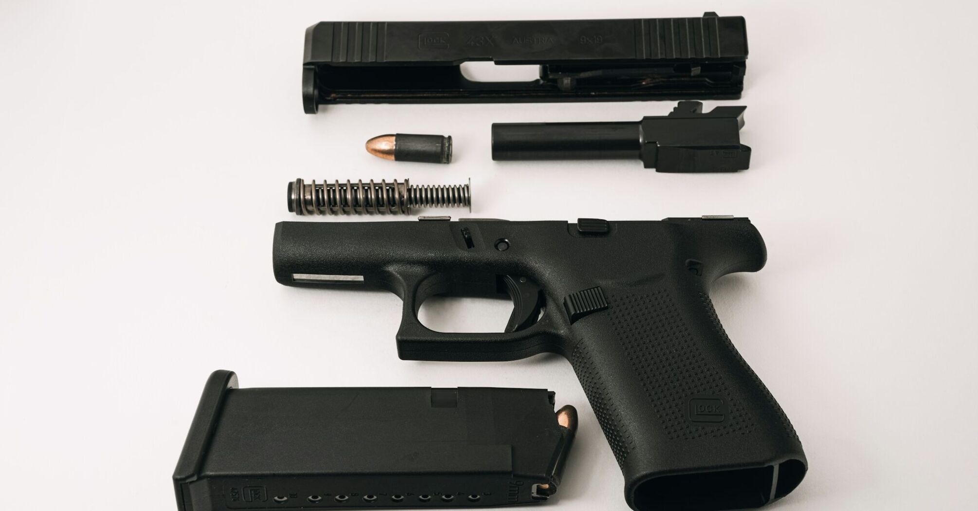 Disassembled handgun with magazine and bullet