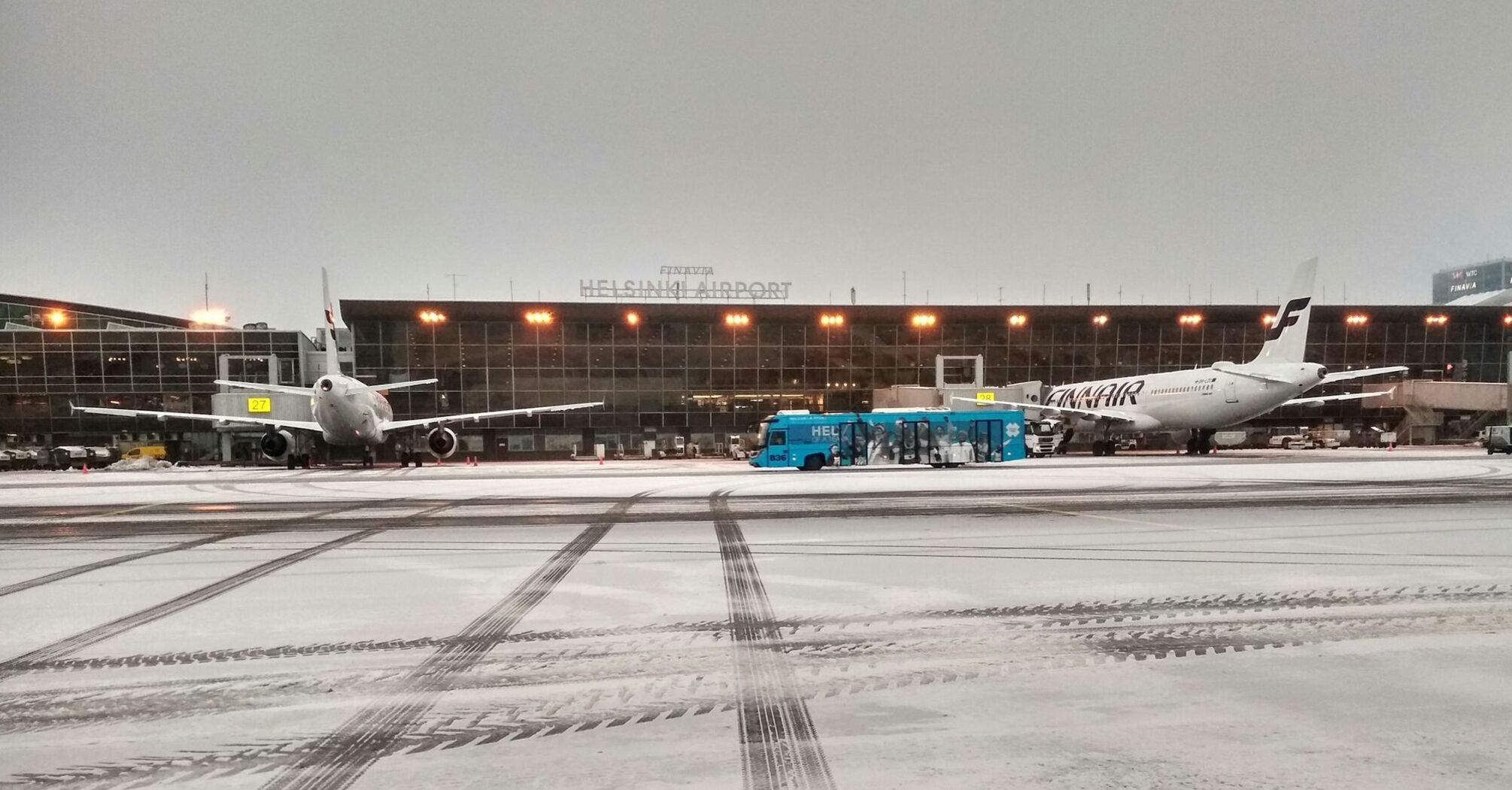 View of Helsinki Airport with Finnair planes and a service bus on a tarmac