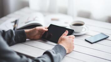 Boy with a tablet in his hands and a cup of coffee on the table