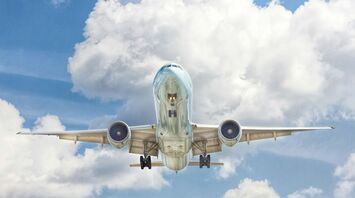 Gray and white airplane on flight near clear blue sky