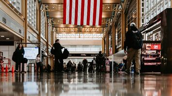 Interior of an airport with a large American flag hanging overhead