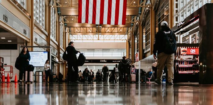 Interior of an airport with a large American flag hanging overhead