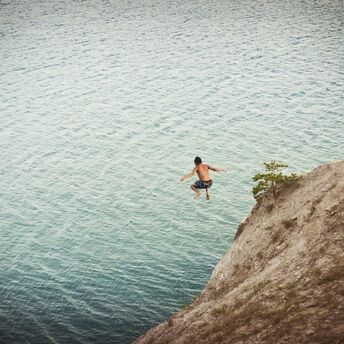 Boy jumping on body of water