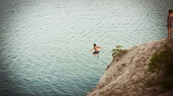 Boy jumping on body of water