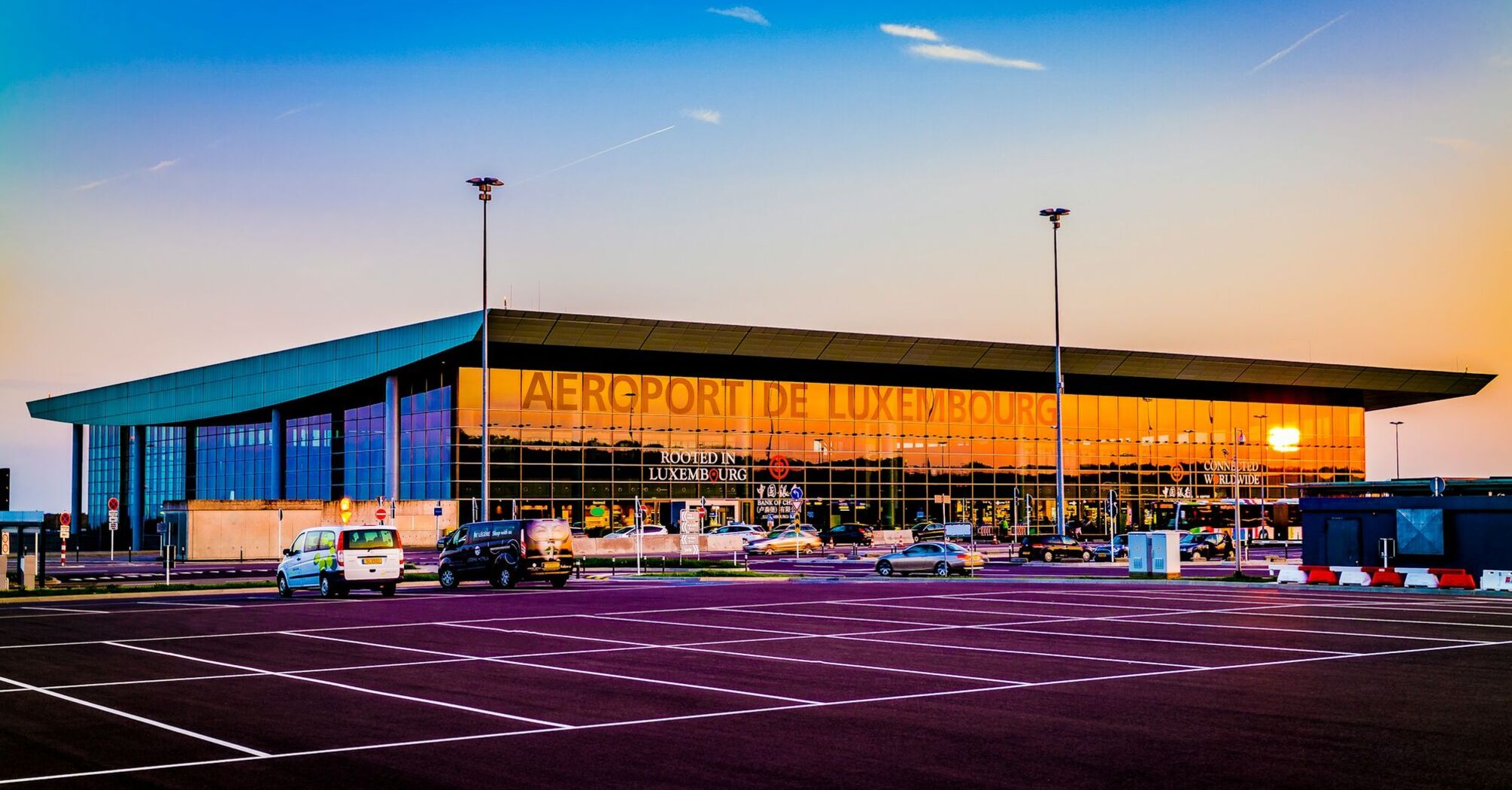Sunset view of Luxembourg Airport with clear skies and parking