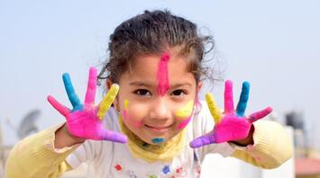 Little girl smeared with paint posing for the camera
