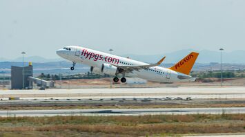Pegasus Airlines aircraft taking off on a sunny day, showcasing the vibrant branding and colors of the airline